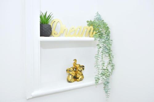 a shelf with plants and a sign that reads gain at London House by YourStays - 5 Bedroom House in Newcastle-under-Lyme in Stoke on Trent