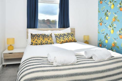 a bedroom with a white bed with pillows and a window at London House by YourStays - 5 Bedroom House in Newcastle-under-Lyme in Stoke on Trent
