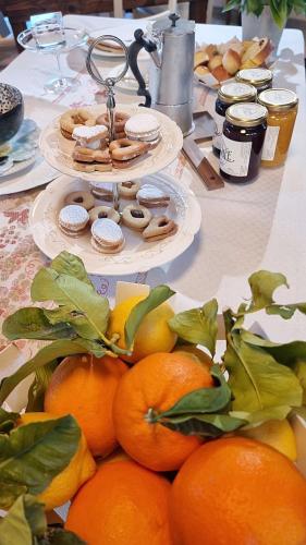 une table recouverte de plaques d'oranges et de pâtisseries dans l'établissement Corte degli OstiNati, à Variano