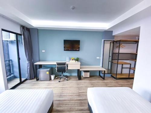 a room with two beds and a desk at MtriO Hotel Korat in Nakhon Ratchasima