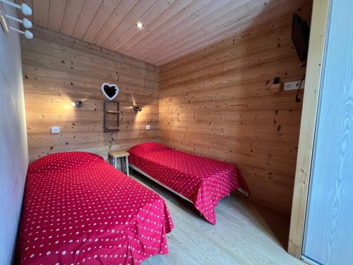 Cette chambre en bois comprend un lit rouge. dans l'établissement Gentianes 3 Bis - Centre village et proche pistes, à La Clusaz
