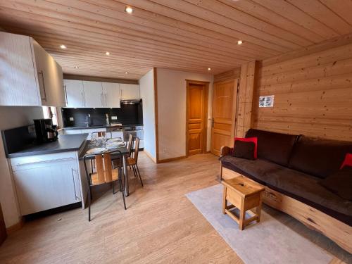 un salon avec un canapé et une cuisine dans l'établissement Gentianes 3 Bis - Centre village et proche pistes, à La Clusaz