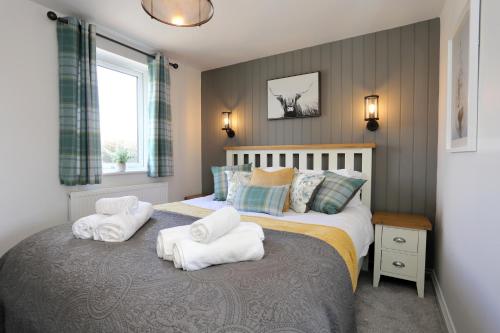 a bedroom with a bed with towels on it at The Wren in Whitchurch