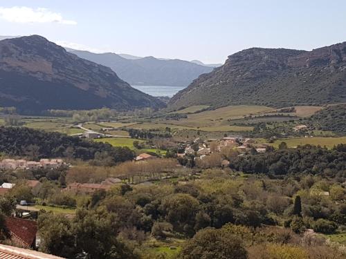 uma vista para um vale com montanhas e um corpo de água em villa bana em Patrimonio