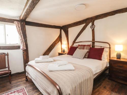 a bedroom with a bed with two towels on it at Tudor Cottage in Sandwich