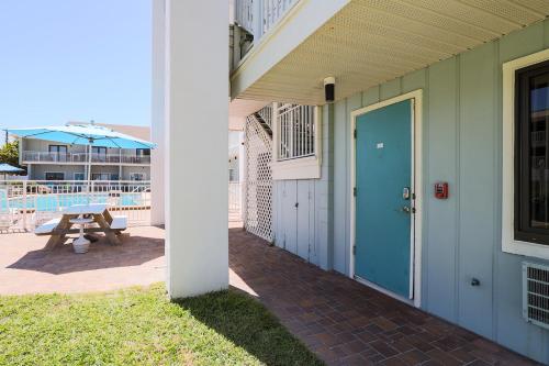 a house with a blue door and a picnic table at Coastal Waters in New Smyrna Beach