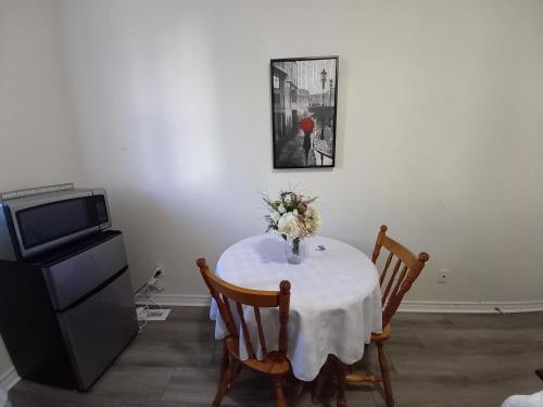 a dining room table with a vase of flowers on it at May Flowers in Kingston