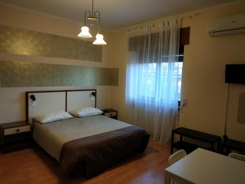 a bedroom with a bed and a window and a table at B&B Villa Filotea & Apartment in Desenzano del Garda