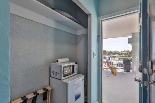 a room with a tv on top of a refrigerator at Coastal Waters in New Smyrna Beach