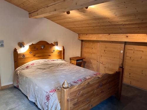 une chambre avec un lit dans une pièce avec des plafonds en bois dans l'établissement Gentianes 4 - Appartement centre village, à La Clusaz