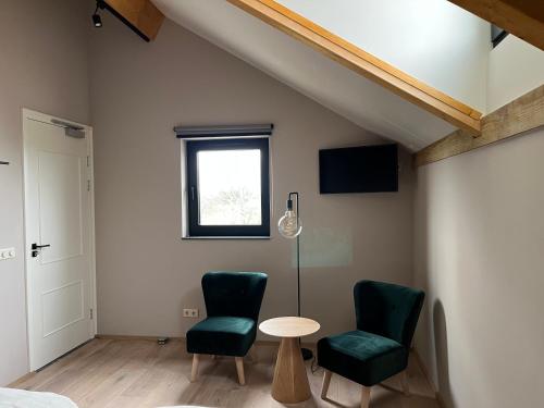 a room with two chairs and a table and a window at De Hoogstam in Vijlen