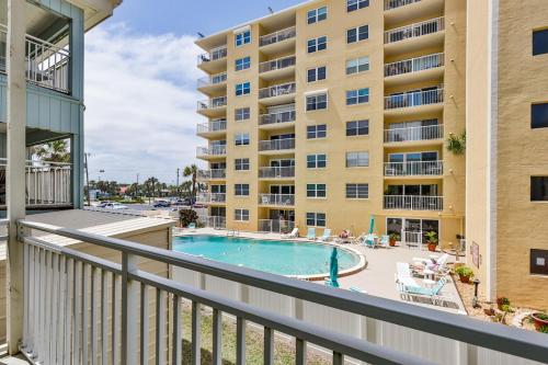 a balcony with a pool and a building at Coastal Waters in New Smyrna Beach