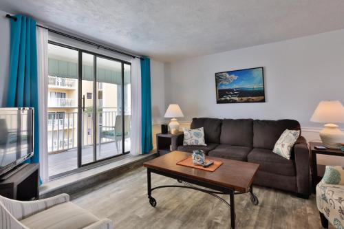 a living room with a couch and a table at Coastal Waters in New Smyrna Beach