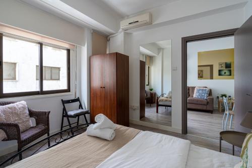 um quarto com uma cama e um espelho e uma sala de estar em Eleni’s 1-BR Apt in Larnaca Center em Lárnaca
