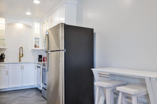 a kitchen with a stainless steel refrigerator and white cabinets at Coastal Waters in New Smyrna Beach
