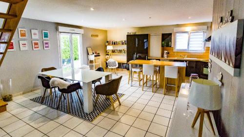 eine Küche und ein Esszimmer mit einem Tisch und Stühlen in der Unterkunft Maison moderne à la campagne in Le Valdahon