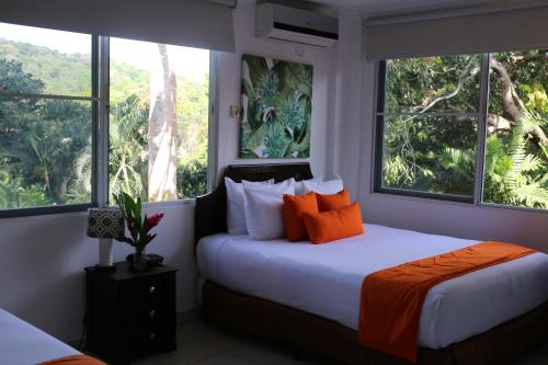 a bedroom with two beds and two windows at Albrook Inn in Panama City
