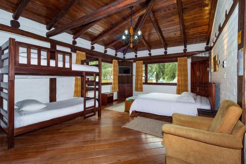 a bedroom with two bunk beds and a couch at Hostal ILÉ in Baños