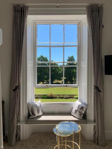 a window seat in a living room with a table at Bartley Lodge Hotel in Lyndhurst