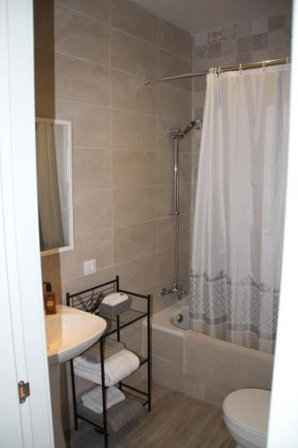 een badkamer met een douche, een toilet en een wastafel bij Apartamento “CALMA” in Tarifa