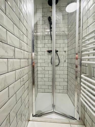 a shower with a glass door in a bathroom at Cheerful 5-bedroom with free parking in Bristol