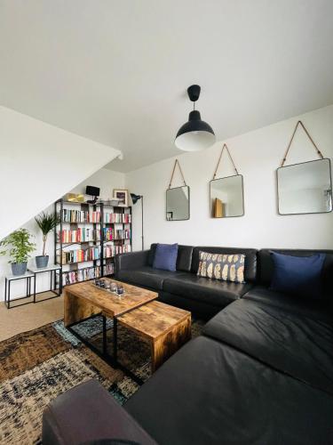 a living room with a black couch and a coffee table at Cheerful 5-bedroom with free parking in Bristol