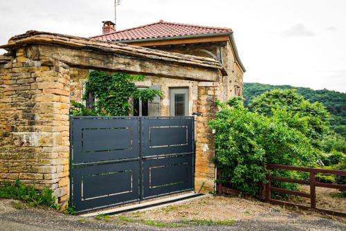 um edifício de tijolos com uma grande porta de garagem azul em LE CLOS DES PIERRES ROUGES em Burgy