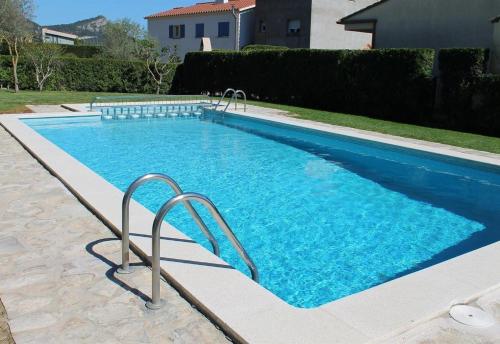 a swimming pool with blue water in a yard at Breda 4a in Torroella de Montgrí