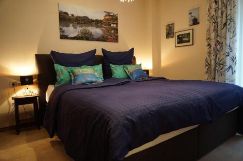 een slaapkamer met een groot bed met blauwe lakens en kussens bij Apartment Apart Waldershof in Waldershof