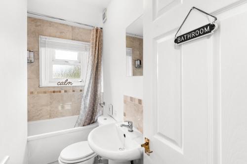 La salle de bains blanche est pourvue d'un lavabo et de toilettes. dans l'établissement Rock Terrace Accommodation - TV in Every Bedroom!, à Morriston