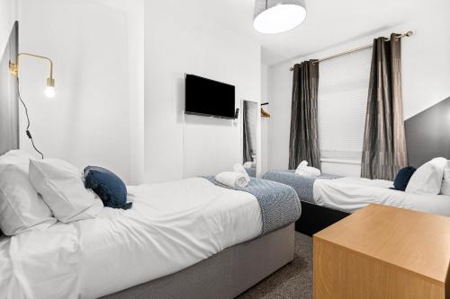 Morriston的住宿－Rock Terrace Accommodation - TV in Every Bedroom!，酒店客房设有两张床和一台平面电视。