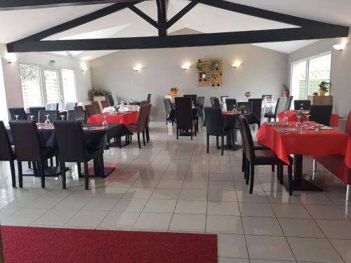 une salle à manger avec des tables, des chaises et des nappes rouges dans l'établissement Lerelaisdetouvent, à Boutenac-Touvent