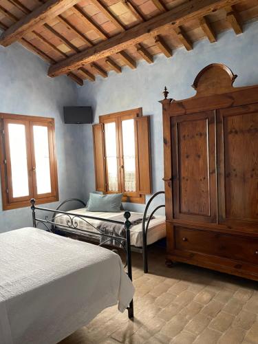 Agriturismo I Bosconi في تشيسينا: غرفة نوم بسريرين وخزانة خشبية