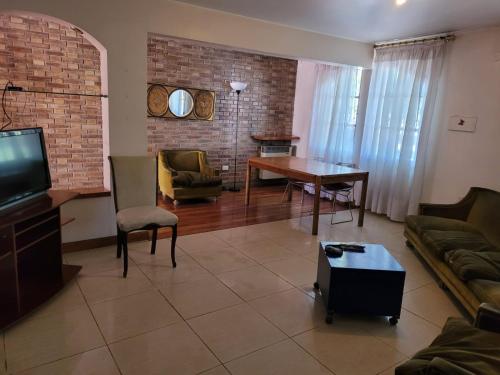 Casa Balcarce في غودوي كروز: غرفة معيشة مع أريكة وطاولة