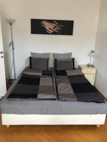 a bed in a bedroom with a black and grey comforter at Rustik Senjak in Sajmište