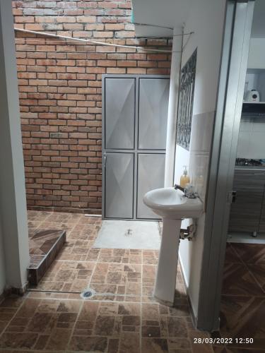 a bathroom with a sink and a brick wall at Hermoso apartaestudio in Pitalito