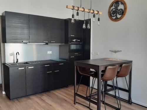 uma cozinha com armários pretos e uma mesa e cadeiras em COSY ZEN HYPER CENTRE APARTMENT*** em Rochefort