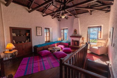 a living room with purple pillows and a couch at My Pelion Home in Lafkos