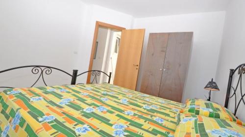 a bed with a colorful comforter in a bedroom at Residence Punta Pizzo in Marina di Mancaversa