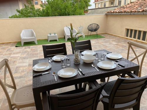 een tafel met borden en keukengerei op een patio bij Casa Melodía in Calahorra