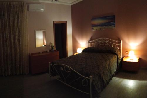 um quarto com uma cama com duas luzes acesas em SoleLuna 319 em Reggio di Calabria