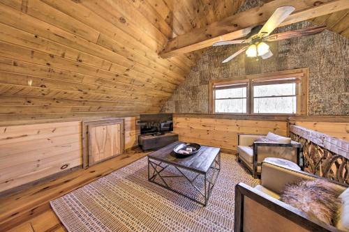 a log cabin living room with a ceiling fan at Stunning Escape with Loft, Hot Tub and Mtn Views! in Morganton