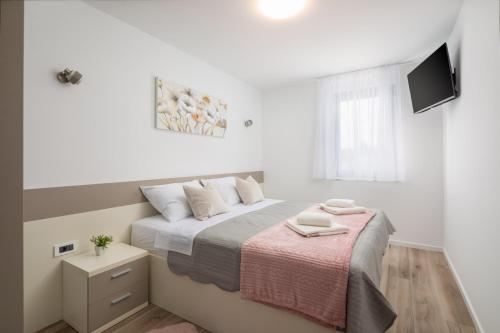 a bedroom with a bed with a pink blanket at Luxury Apartment Blue Sky in Pakoštane