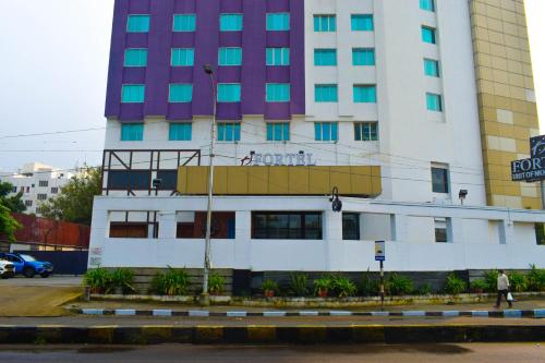 um edifício branco alto com um cartaz em Fortel em Chennai