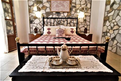 a bedroom with a bed and a table with a tea set at Pasas Castle - Unique Luxury Apartments in Naxos Chora