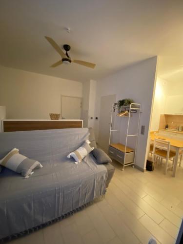 une chambre avec un lit avec un ventilateur de plafond dans l'établissement Entre Plages et Jardins, à Marseille