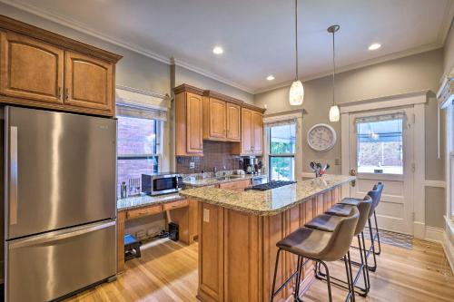 a kitchen with a stainless steel refrigerator and wooden cabinets at Louisville Home with Hot Tub in The Highlands! in Louisville