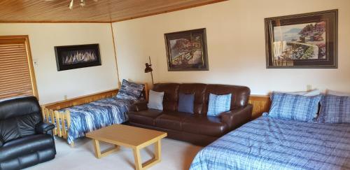 a living room with a couch and a bed at Invermere Luxury 4 Bedroom Mountain Lake View Home - Sleeps 8, 2 decks, Huge Yard, Walk to Town -Beach, Tennis, Golf at 12 Courses - Hot Springs Close By!! in Invermere