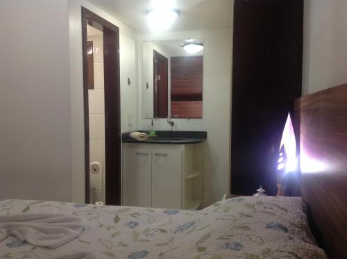 a bedroom with a bed and a sink and a mirror at Apartamentos La Piazzetta Duplex in Pipa