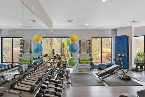 a gym with exercise equipment and large windows at Kasa Dilworth Charlotte in Charlotte